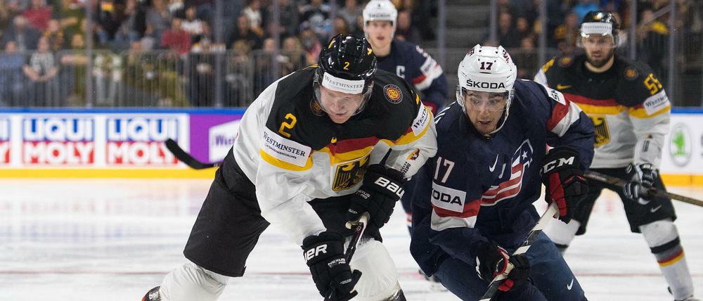 Deutschlands Denis Reul (l) und der US-Amerikaner Nick Schmaltz im Kampf um den Puck.