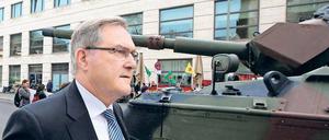 Frontwechsel. Franz Josef Jung spaziert vorbei an den Demonstranten mit ihrem ausgemusterten Panzer. 