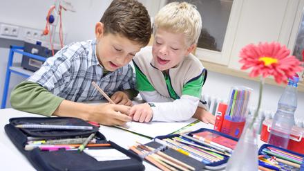 Gemeinsamer Unterricht. Schüler mit und ohne Down-Syndrom in einer Gemeinschaftsschule beim Malen.