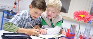 Gemeinsamer Unterricht. Schüler mit und ohne Down-Syndrom in einer Gemeinschaftsschule beim Malen.