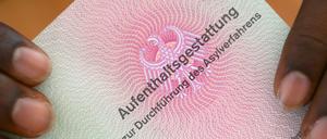 Eine Aufenthaltsgestattung in Händen eines Flüchtlings aus Somalia.