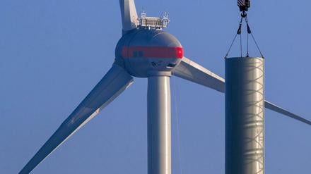 Ein Turmsegment einer neuen Windkraftanlage wird mit einem Kran angehoben. Bei der ersten von drei Ausschreibungsrunden für Windenergie an Land haben sich die norddeutschen Standorte durchgesetzt. 