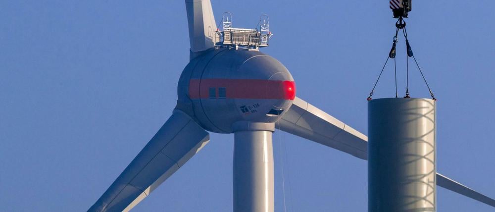 Ein Turmsegment einer neuen Windkraftanlage wird mit einem Kran angehoben. Bei der ersten von drei Ausschreibungsrunden für Windenergie an Land haben sich die norddeutschen Standorte durchgesetzt.