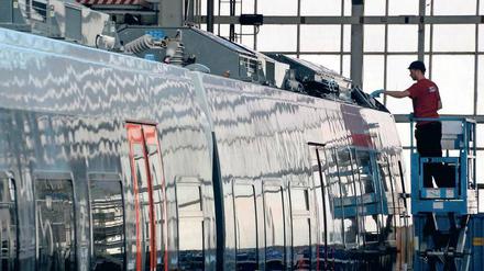 Ein Monteur arbeitet im Bombardier-Werk in Hennigsdorf an einem Zug. 