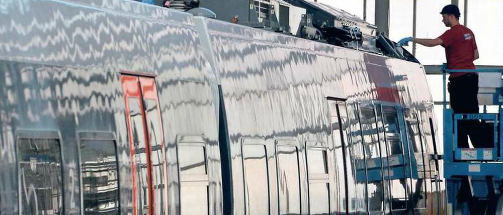 Ein Monteur arbeitet im Bombardier-Werk in Hennigsdorf an einem Zug. 