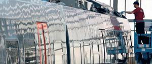 Ein Monteur arbeitet im Bombardier-Werk in Hennigsdorf an einem Zug.