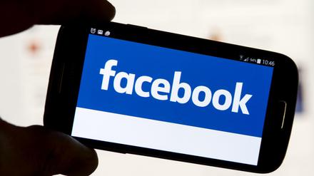 Der Schriftzug der Social Media-Plattform Facebook ist auf einem Handy zu sehen.