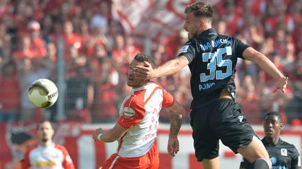 Der Regensburger Marco Grüttner (l) spielt gegen den Münchner Marin Pogracic.
