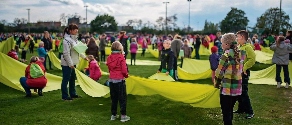 Zahlreiche Kinder proben auf einem Sportplatz in Berlin für die Turnfest-Stadiongala, die am 6. Juni im Berliner Olympiastadion stattfindet.