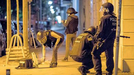 Tatort Friedrichshain: Polizisten sammeln Pflastersteine als Beweismittel ein.