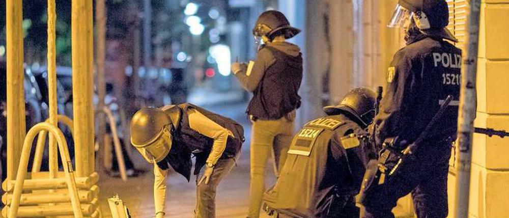 Tatort Friedrichshain: Polizisten sammeln Pflastersteine als Beweismittel ein.