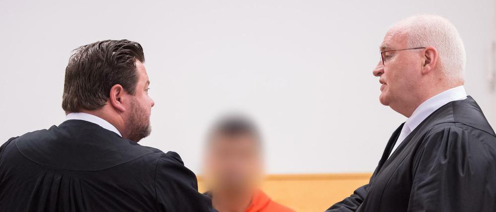 Bastian Quilitz (l) und Matthias Waldraff (r), die Verteidiger von Nurettin B. (M), sprechen am Mittwoch vor Beginn des Prozesses in einem Gerichtssaal im Landgericht in Hannover (Niedersachsen) mit dem Angeklagten.