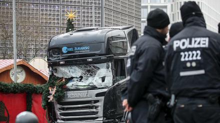 Polizisten stehen vor dem zerstörten LKW am Weihnachtsmarkt am Breitscheidplatz in Berlin. 