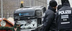 Polizisten stehen vor dem zerstörten LKW am Weihnachtsmarkt am Breitscheidplatz in Berlin. 
