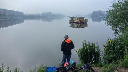 Angler früh am Morgen an der Rummelsburger Bucht, im Hintergrund ein Boot auf dem See.