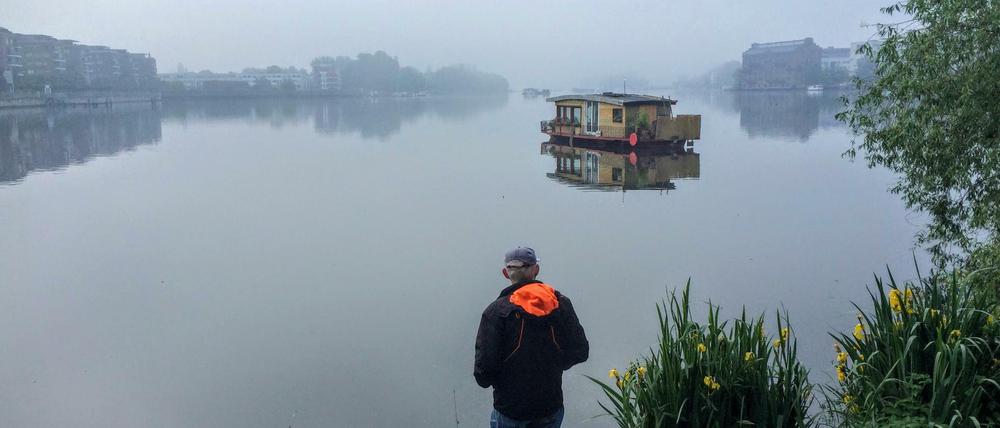 Angler früh am Morgen an der Rummelsburger Bucht, im Hintergrund ein Boot auf dem See.