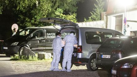 Polizisten der Spurensicherung stehen auf dem Gelände der Asylunterkunft.