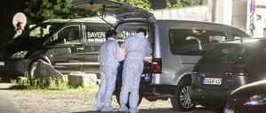 Polizisten der Spurensicherung stehen auf dem Gelände der Asylunterkunft.