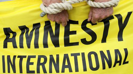 Ein Aktivist von Amnesty International mit symbolischen Fesseln. (Archiv)