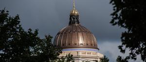 Die Kuppel des Stadtschlosses leuchtet in der Sonne, während ein dunkles Wolkenband vorbei zieht.