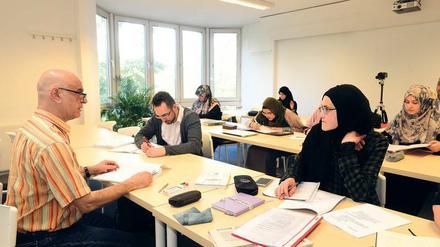 Studierende sitzen in einem Hörssal, zu sehen sind überwiegend junge Frauen, die Kopftuch tragen.