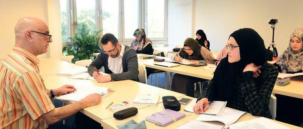 Studierende sitzen in einem Hörssal, zu sehen sind überwiegend junge Frauen, die Kopftuch tragen.