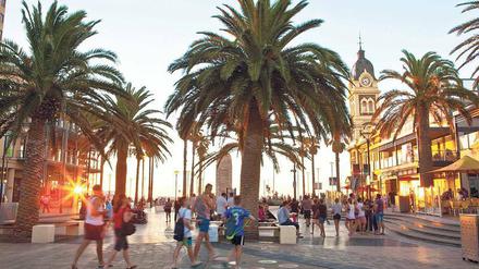 Besucher genießen den Abend auf der Promenade in Glenelg.