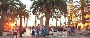 Besucher genießen den Abend auf der Promenade in Glenelg.