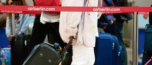 Passagiere in Berlin-Tegel mit ihrem Gepäck an einem Check-in-Schalter von Air Berlin.
