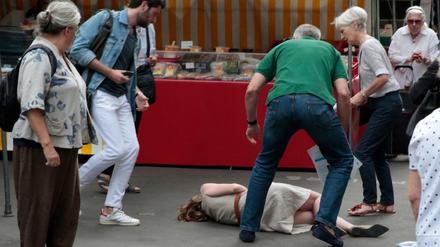 Passanten kümmern sich um die bewusstlose Parlamentskandidatin Nathalie Kosciusko-Morizet.