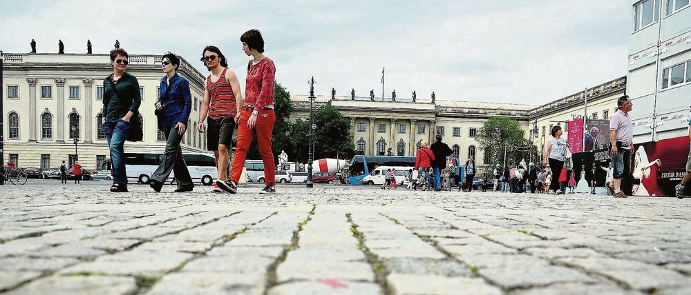 Passanten vor einem historischen Universitätsgebäude.