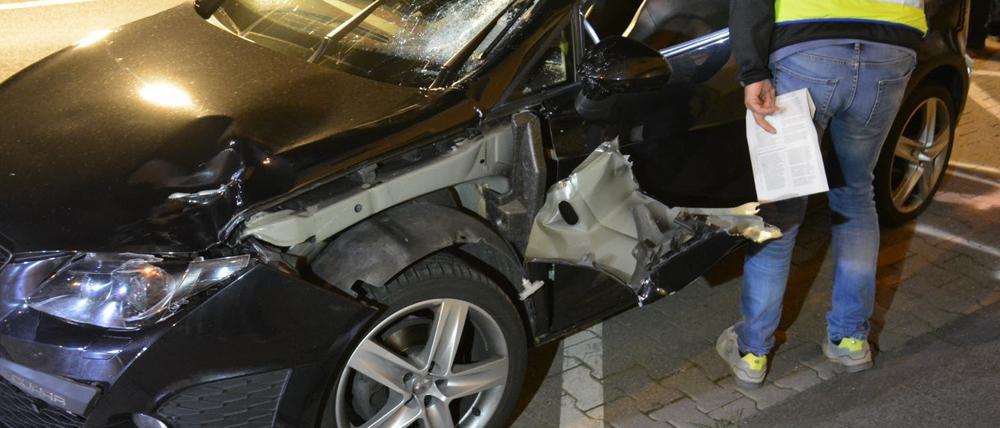 Ein Polizist untersucht das Auto des Rasers an der Unfallstelle in Mönchengladbach.
