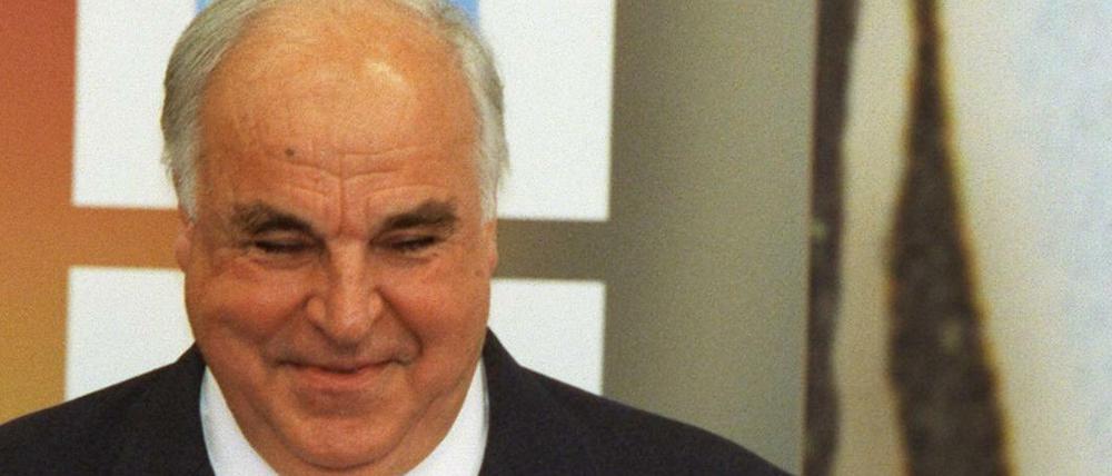 Der Kapitän der Fußball-Nationalmannschaft Jürgen Klinsmann (l) und Jürgen Kohler (r) überreichen 1998 Bundeskanzler Helmut Kohl (M) einen Fußball mit Autogrammen der Mannschaft.