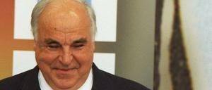 Der Kapitän der Fußball-Nationalmannschaft Jürgen Klinsmann (l) und Jürgen Kohler (r) überreichen 1998 Bundeskanzler Helmut Kohl (M) einen Fußball mit Autogrammen der Mannschaft.
