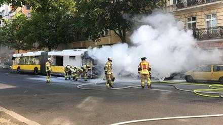 Feuerwehrleute löschen einen Brand an einem Bus der BVG in der Neuköllner Hermannstraße.