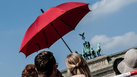 Schutz vor der Sonne: Berlin-Touristen mit Schirm am Brandenburger Tor (Archivbild)