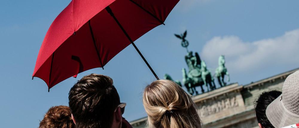 Schutz vor der Sonne: Berlin-Touristen mit Schirm am Brandenburger Tor (Archivbild)