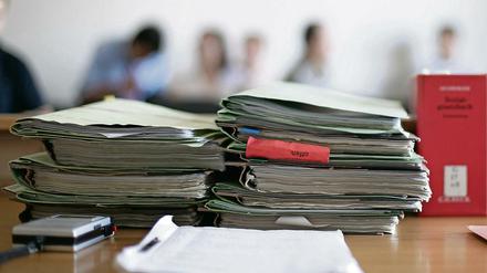 Aktenordner liegen im Sozialgericht zu Beginn einer Verhandlung auf dem Tisch. 