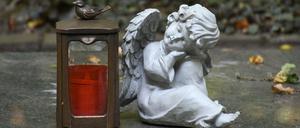 Ruhe in Frieden. Eine Engelsfigur auf einem Grabstein im Waldfriedhof.