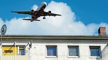 Ein Flugzeug nähert sich über einem Wohngebiet dem Flughafen Tegel.