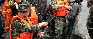 Hilfskräfte auf einer Straße in dem Dorf Xinmo (China) in der südwestchinesischen Provinz Sichuan.