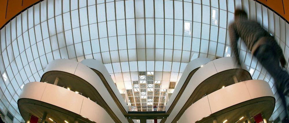 Studierende gehen durch das Foyer einer Universitätsbibliothek.