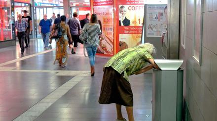 Ein Alter in Würde sieht anders aus: Eine alte Frau sammelt Flaschen aus Abfalleimern im Hauptbahnhof in Mülheim an der Ruhr.