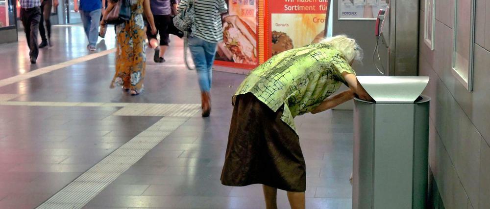 Ein Alter in Würde sieht anders aus: Eine alte Frau sammelt Flaschen aus Abfalleimern im Hauptbahnhof in Mülheim an der Ruhr.