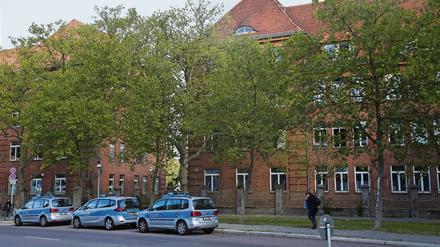Hinten die Kaserne, davor Autos der Berliner Polizei - die Wache befindet sich auf der anderen Straßenseite.
