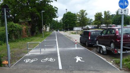 Berlin-Spandau. Links ein Gitter auf dem Radweg, daneben - getrennt durch eine Linie - fast freie Fahrt.