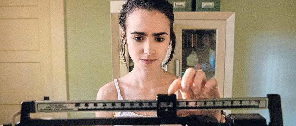 Ellen (Lily Collins) muss feststellen, dass sie weiter an Gewicht verlieren. Szene aus dem Netflix-Film "To the Bone".