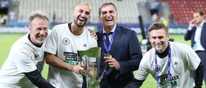 Vier gewinnt. Stefan Kuntz (Zweiter von rechts) mit seinem Trainer-Gespann - und dem EM-Pokal. 