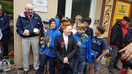 Unvergessen. George Shefi mit Kindern der Löcknitz-Grundschule vor seinen alten Wohnhaus, wo er als Kind lebte, in der Hauptstraße 5 in Schöneberg. Jetzt wurden Stolpersteine für seine Mutter Marie Spiegelglas und seine Tante Margit Benedik vor dem Haus verlegt, das er als Siebeneinhalbjähriger mit den "Kindertransporten" zum Schutz vor der Ermordung durch die Nationalsozialisten verließ. Das Gedenken organisierte federführend der Wilmersdorfer Musikverleger und Freund der Familie aus Israel, Australien und Deutschland, Horst Brauner.