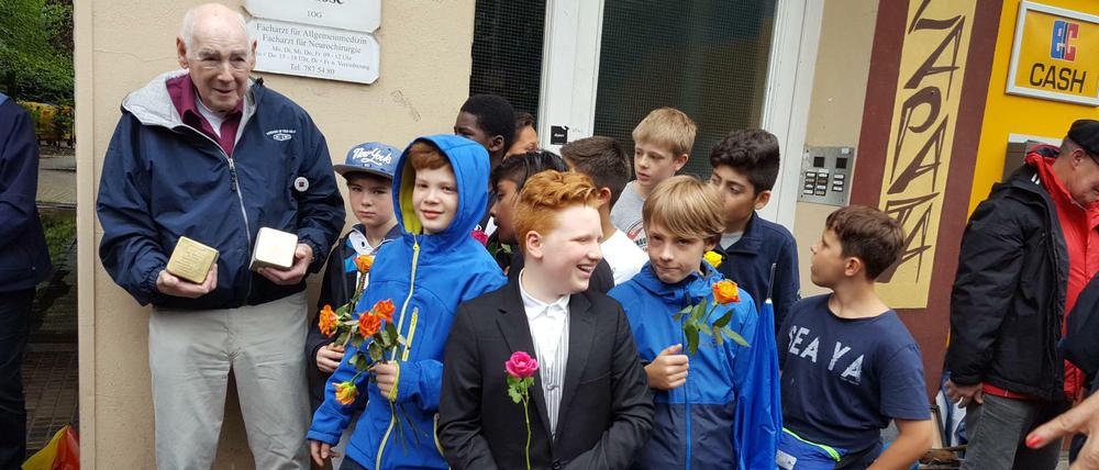 Unvergessen. George Shefi mit Kindern der Löcknitz-Grundschule vor seinen alten Wohnhaus, wo er als Kind lebte, in der Hauptstraße 5 in Schöneberg. Jetzt wurden Stolpersteine für seine Mutter Marie Spiegelglas und seine Tante Margit Benedik vor dem Haus verlegt, das er als Siebeneinhalbjähriger mit den "Kindertransporten" zum Schutz vor der Ermordung durch die Nationalsozialisten verließ. Das Gedenken organisierte federführend der Wilmersdorfer Musikverleger und Freund der Familie aus Israel, Australien und Deutschland, Horst Brauner.